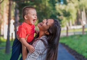 Mother and baby laughing together outdoors
