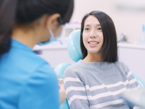 Woman in dental chair smiling at lip and tongue tie specialist