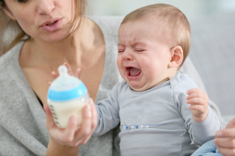 A baby with colic due to a lip or tongue-tie