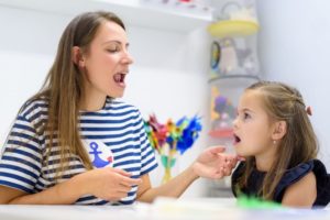 Myofunctional therapist working with young child